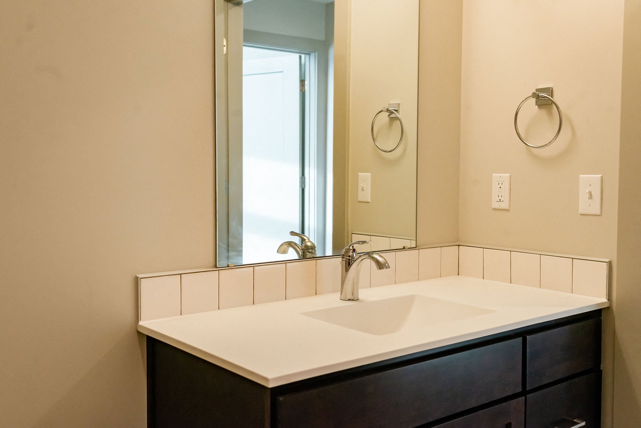 modern bathroom with dark vanity and light countertop
